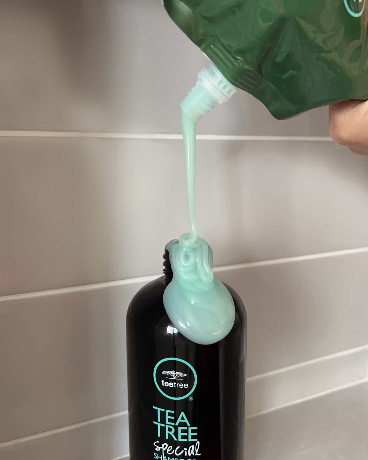 refilling a bottle of tea tree special shampoo