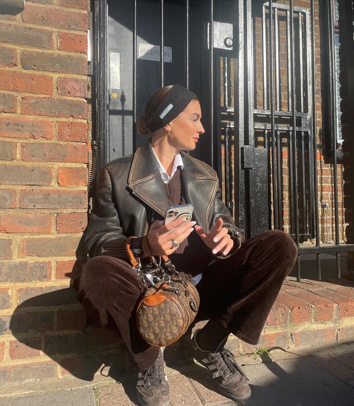 Influencer @camillecharriere wears brown trainers with brown corduroy trousers and a brown leather jacket.