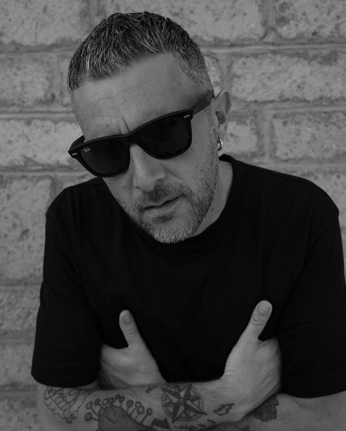 man in black t-shirt wearing a ray-ban wayfarer