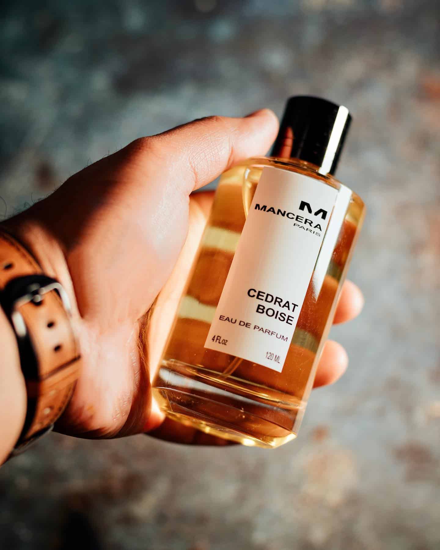 holding a bottle of cedrat boise cologne by mancera
