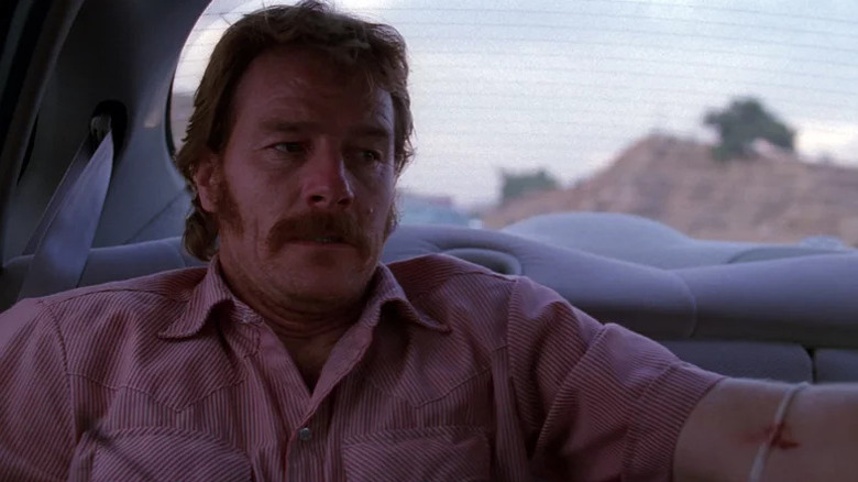 Bryan Cranston's Patrick Crump sitting at the back of a car and looking concerned on The X-Files