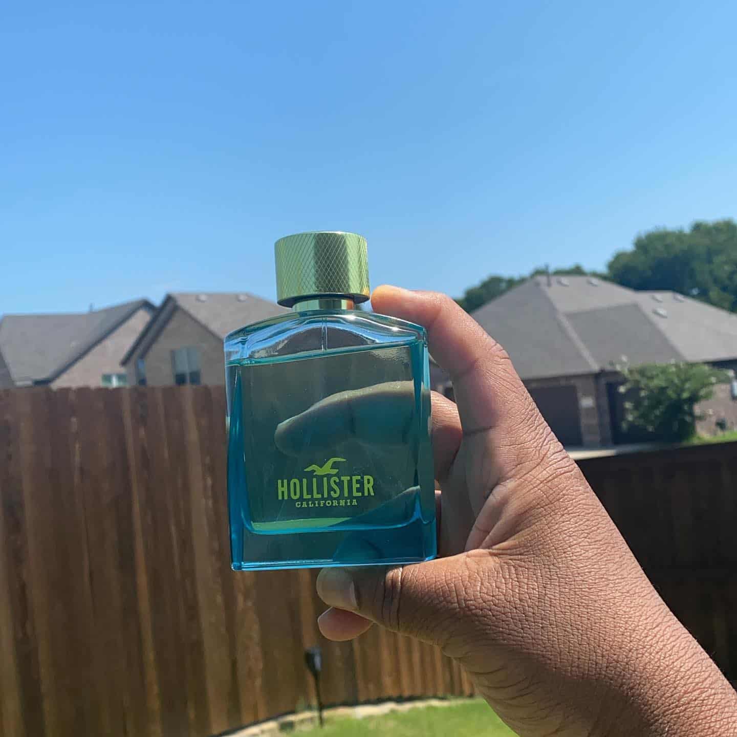 man holding a bottle of hollister wave 2 cologne